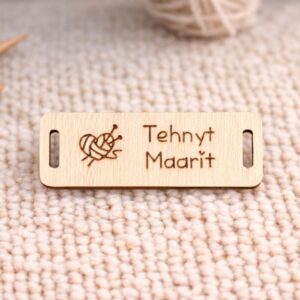suorakaiteen muotoinen käsityömerkki koivuvanerista johon kaiverrettu sydänmen muotoinen lankakerä ja teksti tehnyt maarit
